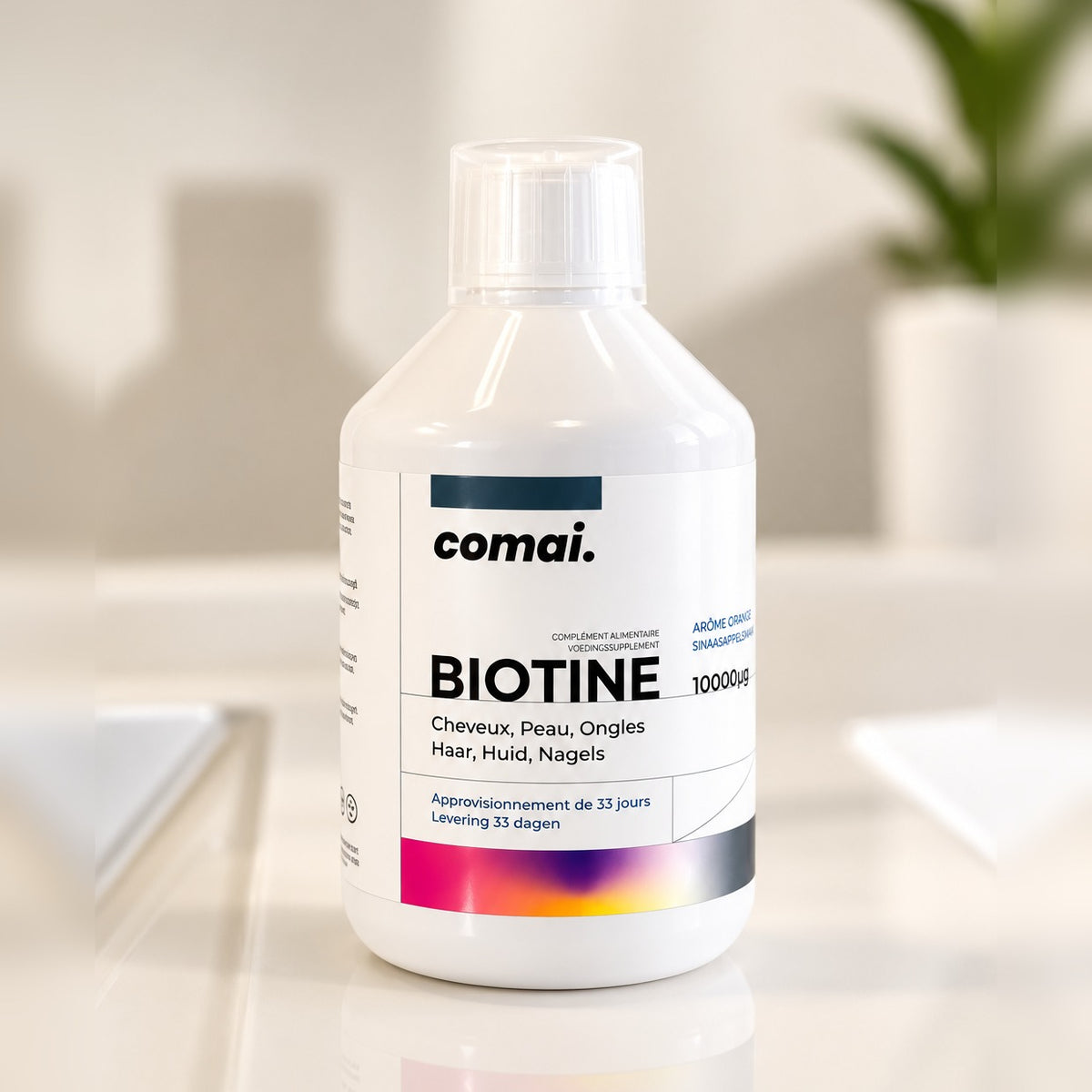 Flacon COMAI BIOTINE 500 ml, complément alimentaire liquide à la biotine et à la vitamine C, arôme orange, posé dans une salle de bain